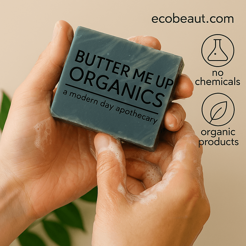 Person holding a lathered 'Butter Me Up Organics' soap bar while washing hands, with green leaves in the background, and eco labels 'no chemicals', 'organic products', and website ecobeaut.com displayed in the upper right corner.