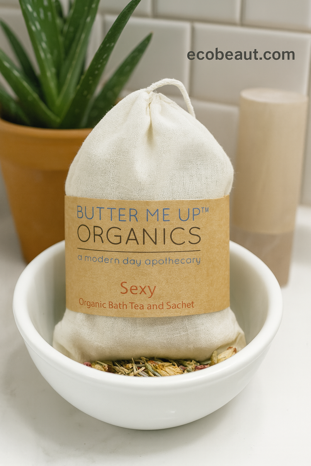 Butter Me Up OrganicsSexy organic bath tea and sachet in a bowl with a plant and product in the background.