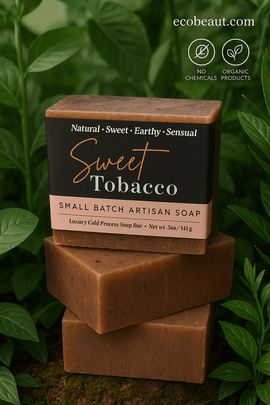  Sweet Tobacco artisan soap bar by ecobeaut.com surrounded by lush green plants, with “NO CHEMICALS” and “ORGANIC PRODUCTS” icons in the upper right corner.