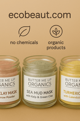 Three Butter Me Up Organics face masks—Rose Clay, Sea Mud, and Turmeric—displayed in glass jars on a wooden tray with greenery, "no chemicals", "organic products" icons, and ecobeaut.com in the top right corner