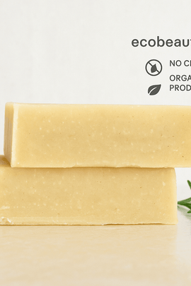 Two natural Citrus Mango Shampoo stacked on a light surface with ecobeaut.com, No Chemicals, Organic Products labels and a sprig of rosemary.