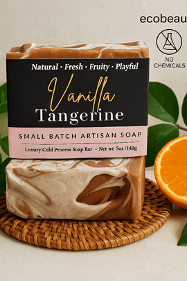Vanilla Tangerine soap bar by ecobeaut.com placed on a rattan mat with fresh green leaves and an orange slice, featuring “NO CHEMICALS” and “ORGANIC PRODUCTS” icons in the upper right corner.




