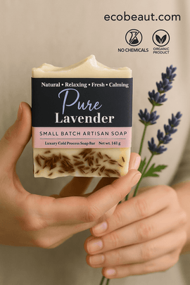 Woman’s hands holding Pure Lavender handmade soap bar with visible lavender buds, set against a soft natural background, featuring ecobeaut.com and “NO CHEMICALS” / “ORGANIC PRODUCT” icons in the upper right corner.