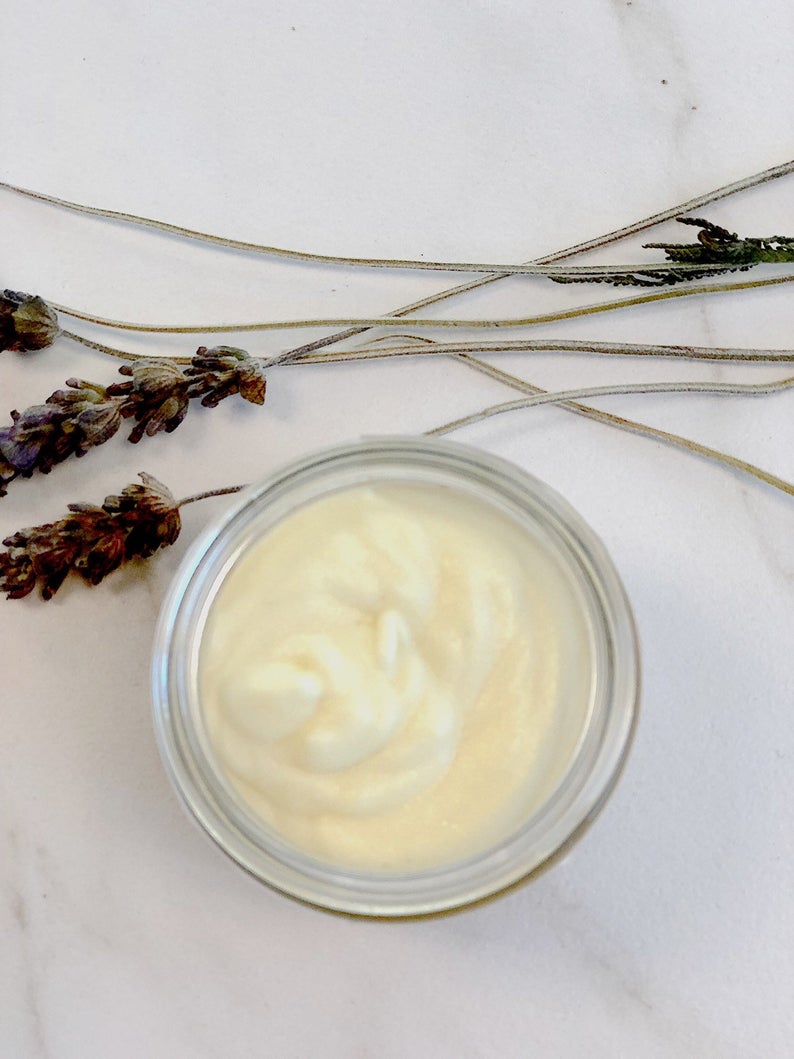 Jar of cream with lavender flowers on a marble surface