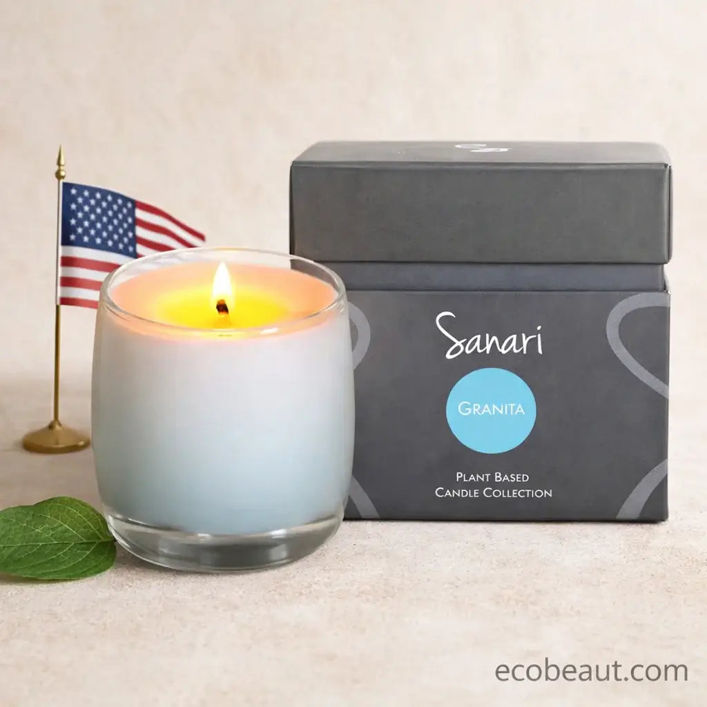 Lit candle in a glass container next to a gray box labeled 'Sanari Granita' on a beige surface.