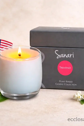 Sanari candle with packaging and flowers on a light background