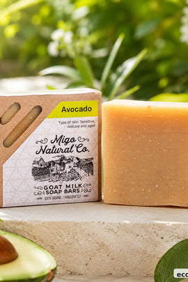 A bar of Miga Natural Co. Goat Milk Soap Bars in the Avocado scent, shown next to its kraft paper packaging box.