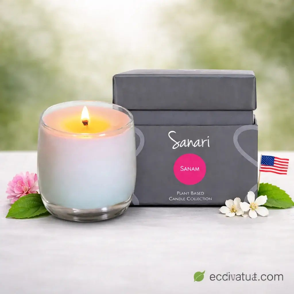 Lit candle in a glass holder next to a gray box labeled 'Sanari' on a white surface with flowers.