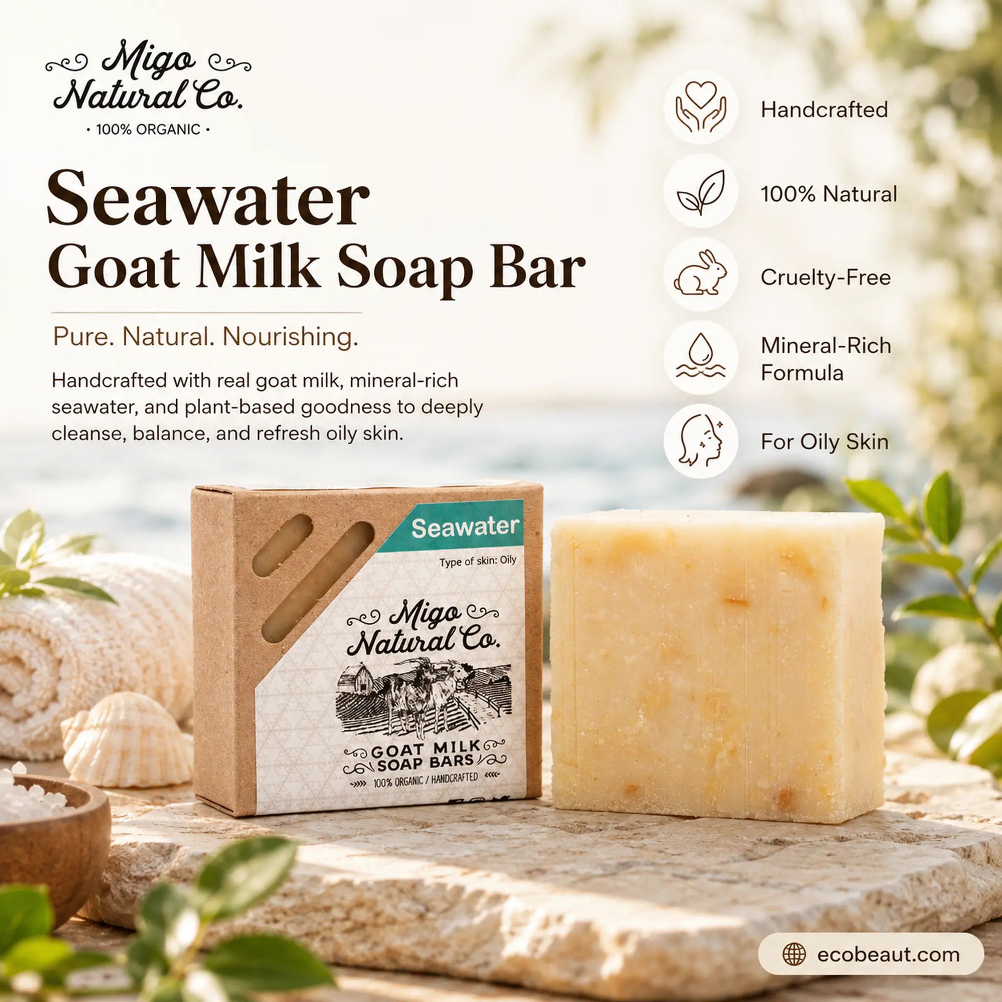 Miga Natural Co. Seawater Goat Milk Soap Bar shown with its kraft paper packaging box and a bar of pale yellow soap beside it, styled on a stone surface with rolled towels, shells, and greenery.