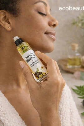 Woman holding a bottle of 'Inner Essence' product with a blurred background featuring a bath tray and plants.