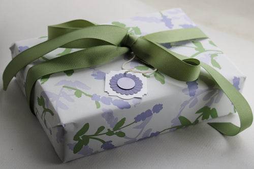 EcoBeaut.com luxury organic skincare gift box with floral wrapping paper and green ribbon, eco-friendly wellness present USA