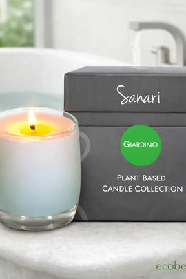 Sanari Giardino plant-based candle collection with a lit candle and packaging on a bathroom counter.